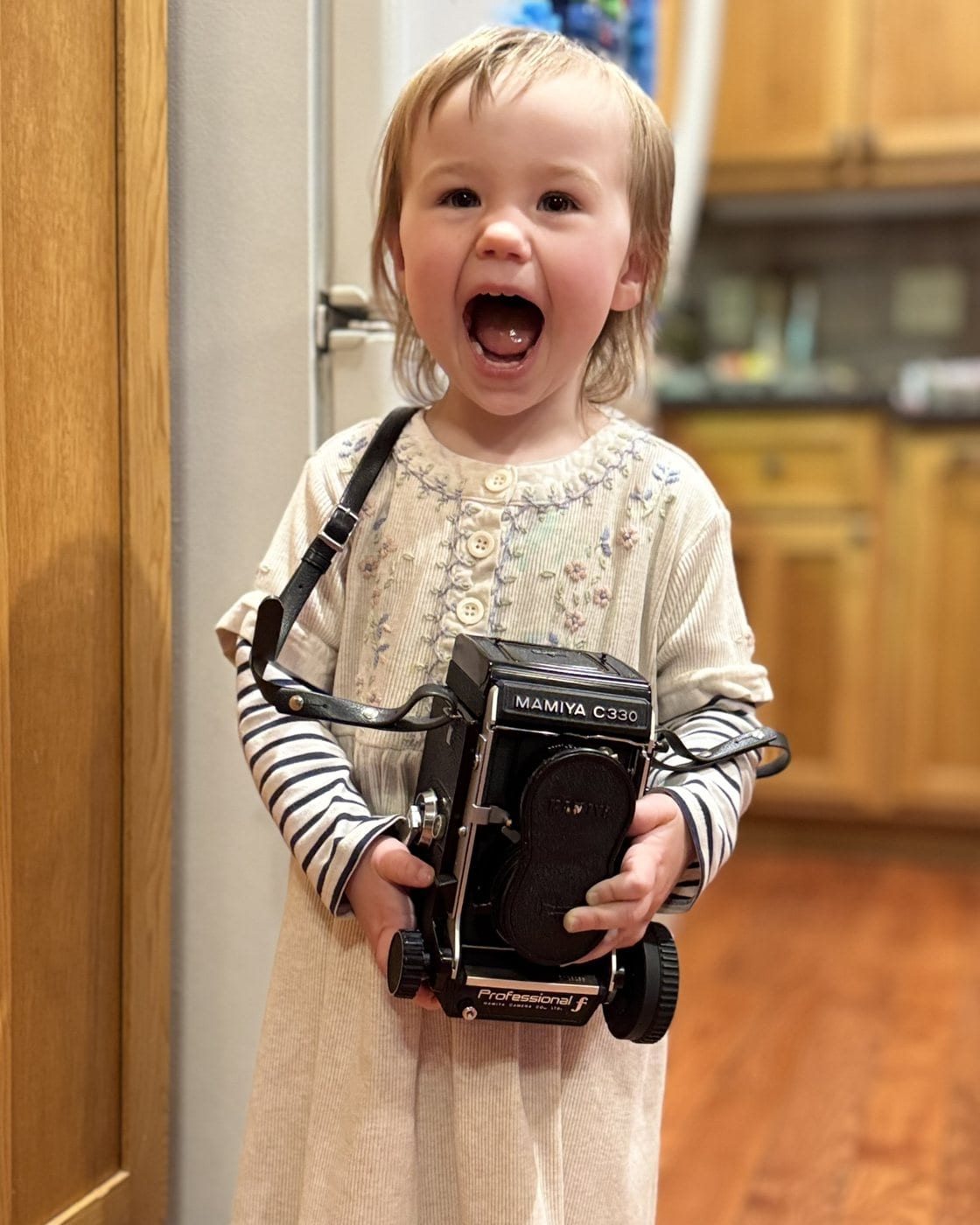 A small boy holding a film camera