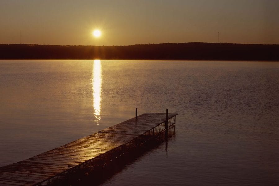 Sunrise over a lake from a wooden dock